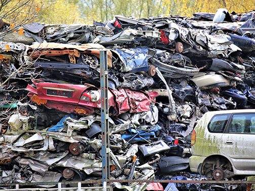 crushed cars stacked in automotive salvage yard