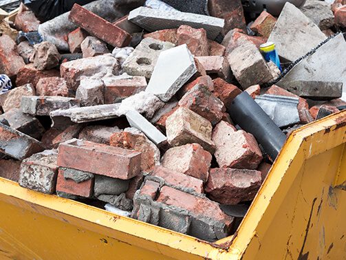 bricks in yellow dumpster