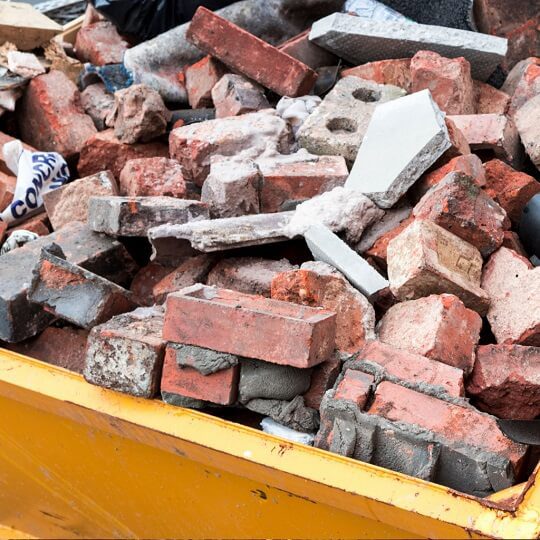 bricks in yellow dumpster