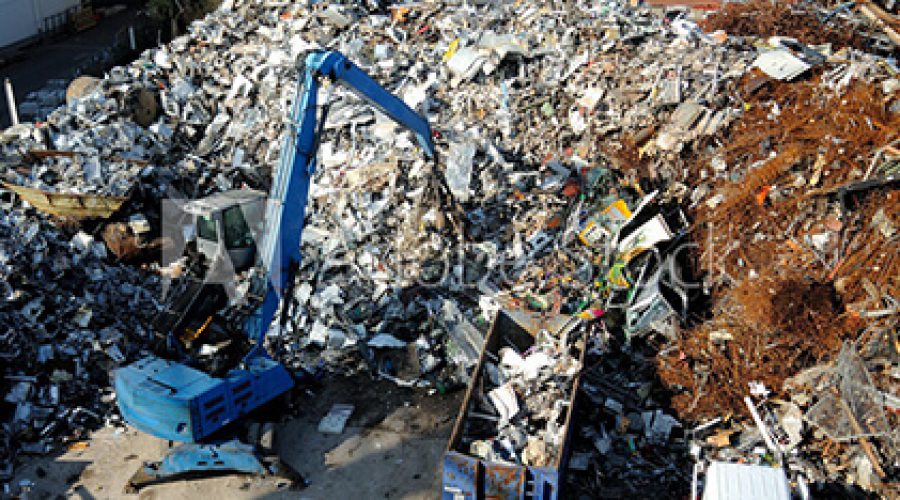 warehouse-knockdown backhoe sifting through debris